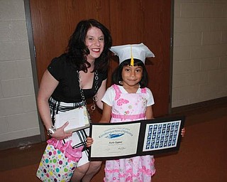 Kate Coppola is with her teacher, Miss Firmstone, after graduating from kindergarten at Lowellville K-12 campus in June 2009.