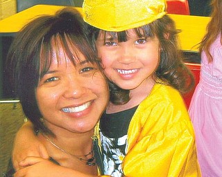 Chloe Noele Ballesteros gets a huge from her mother, Alison, after graduating from St. Rose Church kindergarten in Girard on June 8.