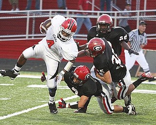 STRUTHERS - GIRARD - (4) Kevin McDonald of Struthers breaks away from (2) Dan Graziano (35) Josh Alexander and (22) Daitzel Moore during their game Friday night. - Special to The Vindicator/ Nick Mays