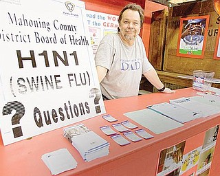 Medical Director of Mahoning County District Board of Health, John Venglarcik M.D., stands at a booth dedicated to dispersing information on the H1N1 Virus at the Canfield Fair on Saturday afternoon.