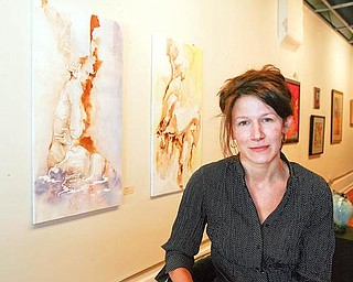 SALEM GALLERY: Kristina Danklef Moore sits near two of her paintings at DH Gallery in Salem. The recently reopened gallery is at 515 E. State St.
