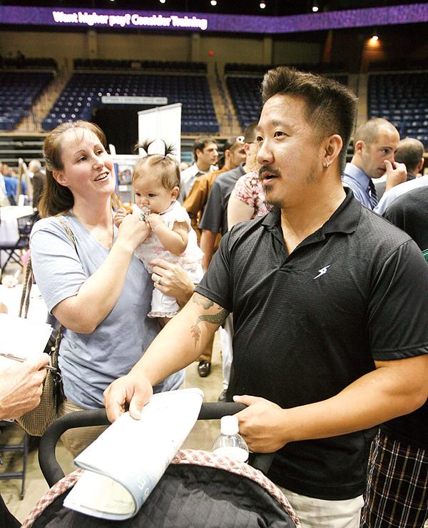 JOB SEARCH: Joel and Penny Johnson of Warren attended Job Expo 2009 at the Covelli Center  with their 4-month-old daughter, Lily. Both 31-year olds lost their jobs when Leedsworld, a maker of promotional supplies, closed its Warren plant in April. Thousands of jobless people packed the downtown arena Wednesday. 
