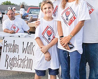TEAM EFFORT: Colton Lockner and his mother Robyn, right; and his aunt Rose Fusco, rear right, stand with Allison Barber, a creator of the Freedom Walk in Washington, D.C. They were in the Lake Shore Plaza parking lot Thursday for Lake Milton’s “America Supports You” Freedom Walk to show support for the U.S. military.