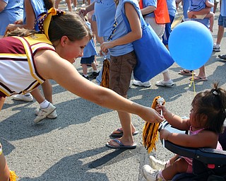 South Range Senior cheerleader Jesse Heck passes out pom-poms at the
Buddy Walk held at Shops on Boardman Park