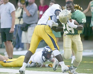 The Vindicator/Robert K. Yosay ---Ursulines #28 Allen Jones looses his helmet as he crossed the goal line -as Viking #8 Malik Johnson fails to bring him down during first quarter action at  Wheeling Island Stadium 952009