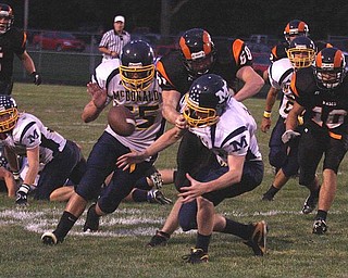 MCDONALD - MINERAL RIDGE - (15) Miles Dunlap (55) Trent Clay fight for a lose ball as (60) Brian Sherba tries to make the play during their game Friday night. - Special to The Vindicator/Nick Mays