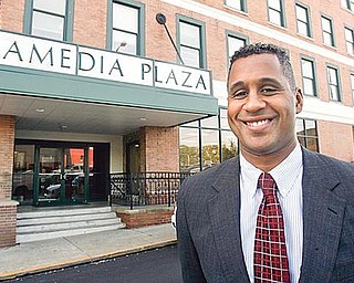 HOUSING FACE-LIFT: Clifford Scott, executive director of the Youngstown Metropolitan Housing Authority, shows off exterior awning improvements funded by federal stimulus money at the Amedia Plaza senior high rise in downtown Youngstown, where the authority’s headquarters are located.    