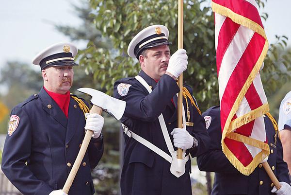 HONOR GUARD: Austintown firefighters John Fritz, left, and Tom Neff stand at attention as part of a special honor guard during a Sept. 11 memorial service in the township. There was a moment of silence as volunteers tolled a bell to symbolize the multiple crashes during the terrorist attacks.