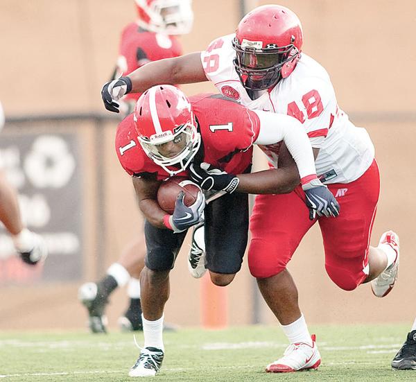 YSU's Kevin Smith (1) is caught by Austin Peay's Nick Clark (48) while driving down field during the fourth quarter on Saturday afternoon at Stambaugh Stadium.