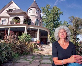 Therese Powell sits outside her recently forclosed home of more than 20 years on Youngstown's North Side. The local activist is the co-chairwoman of Peace Action — Youngstown.