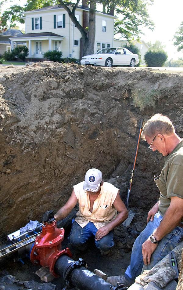 MEN AT WORK: Workers from J.S. Northeast Co., Girard, inspect an area where the new 12-inch waterline will replace the current 6-inch line along North High Street in Cortland. 