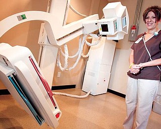 HIGH TECH: Nancy Walker, a resident of Howland and a 30-year employee at St. Joseph Health Center, stands beside a new GE Definium 5000 digital-imaging machine at the new and expanded Urgent Care Center on the St. Joseph Campus on Niles-Cortland Road in Howland. Walker is one of the technicians who operate the high-tech device.