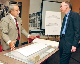 PROJECT MOVING AHEAD: Tony Hayek, left, an architect with MS Consultants Inc. of Youngstown, explains two possible roof styles for the proposed WATTS indoor athletic-training facility at Youngstown State University to YSU Trustee John Jakubek. 