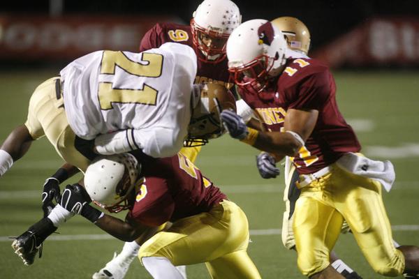 The Vindicator/Robert K. Yosay  -- tied up at the line by three Mooney defenders #21 Harding Deaver Williamson is hit by #5 Braylon Heard  #9 Chuck Grober and #11 Geroge Lyras - during first half action at Stambaugh Stadium - -----9-18-2009