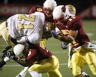 The Vindicator/Robert K. Yosay  -- tied up at the line by three Mooney defenders #21 Harding Deaver Williamson is hit by #5 Braylon Heard  #9 Chuck Grober and #11 Geroge Lyras - during first half action at Stambaugh Stadium - -----9-18-2009