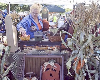 The Vindicator/Lisa-Ann Ishihara-- Tracy Lowen on Austintown looks through Primitive Wood Folk items located in Warren... One of 125 vendors for Market on the Green sponsored by Canfield Junior Women's League, Saturday September 19, 2009