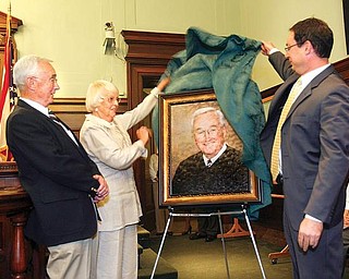 HIS HONOR: Retired Judge Charles J. Bannon, left, watches as his wife Joan and their son Breen, unveil a portrait of him in Judge James C. Evans’ court room on Tuesday in the Mahoning County Courthouse.