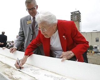 The Vindicator/Robert K. Yosay ----- MAKING HER MARK IN HISTORY - like the proverbial John Hancock... Helen Stambaugh with Paul McFadden....  signs THE BEAM  as  University officials and others will sign the final steel beam going into the $34,3 million building.  The beam, carrying U.S. and YSU flags, will then be hoisted into place.  110,000-square-foot facility to  ready for occupancy in fall 2010.  YSU is raising $16 million in private donations to help pay for the construction. 

0232009