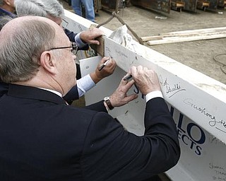 The Vindicator/Robert K. Yosay ----- MAKING A MARK IN HISTORY - like the proverbial John Hancock... Dr David Sweet  signs THE BEAM  as  University officials and others will sign the final steel beam going into the $34,3 million building.  The beam, carrying U.S. and YSU flags, will then be hoisted into place.  110,000-square-foot facility to  ready for occupancy in fall 2010.  YSU is raising $16 million in private donations to help pay for the construction. 

0232009