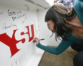 The Vindicator/Robert K. Yosay ----- MAKING HER MARK IN HISTORY - like the proverbial John Hancock... Lara Melnik of Lowellville signs THE BEAM  as  University officials and others will sign the final steel beam going into the $34,3 million building.  The beam, carrying U.S. and YSU flags, will then be hoisted into place.  110,000-square-foot facility to  ready for occupancy in fall 2010.  YSU is raising $16 million in private donations to help pay for the construction. 

0232009