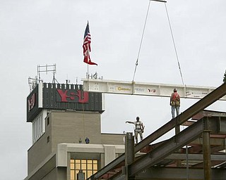 The Vindicator/Robert K. Yosay ---Kevin Conway and Ted Nickoloff Local 207 Ironworkers guide  THE BEAM  as  University officials and others will sign the final steel beam going into the $34,3 million building.  The beam, carrying U.S. and YSU flags, will then be hoisted into place.  110,000-square-foot facility to  ready for occupancy in fall 2010.  YSU is raising $16 million in private donations to help pay for the construction. 

0232009
