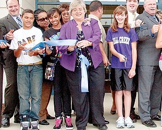 Principal Diane Hunsbarger helps cut a ceremonial ribbon alongside students, faculty, school board administrators, consultants and others outside the new Volney Rogers Middle School during its Open House and Ribbon Cutting Ceremony Wednesday evening.
