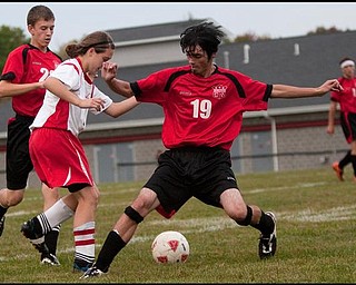The Vindicator/Geoffrey HauschildColumbiana's Steven Kosonovich (19) struggles for control over the ball against Mathew's Sarah Courey (2) during the second half of a game at Mathews on Thursday evening. The game ended in a tie 1-1.9.24.2009