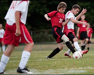 The Vindicator/Geoffrey HauschildMathew's Jason Buzzeo (8) struggles for the ball against Columbiana's Jeff Schallick (26) during a game at Mathews on Thursday evening. The game ended in a tie 1-1.9.24.2009