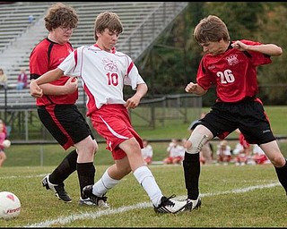 The Vindicator/Geoffrey HauschildColumbiana's Jeff Schallick (26) manages to kick the ball away before being confronted by Mathews' Marcus Durig (10) during the first half of a game at Mathews on Thursday evening. Columbiana's Leighton Bussard (6) can be seen at back left, the game ended in a tie 1-1.9.24.2009