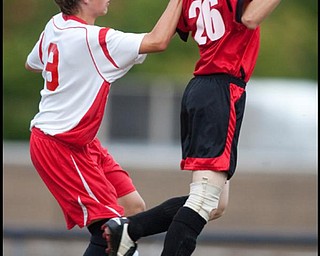 The Vindicator/Geoffrey HauschildMathews' Tyler Hovanec (9) pulls down on the shoulders of Columbiana's Jeff Schallick (26) and lines up for a header during a game at Mathews on Thursday evening. The game ended in a tie 1-1.9.24.2009