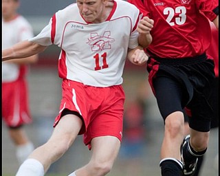 The Vindicator/Geoffrey HauschildMathews' David Kiepper (11) kicks a pass as he is defended by Columbiana's Jacob Witmer (23) during a game at Mathews on Thursday evening. The game ended in a tie 1-1.9.24.2009