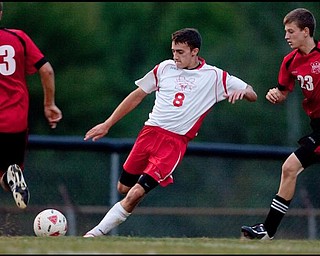 The Vindicator/Geoffrey HauschildMathew's Jason Buzzeo (8) kicks a pass while pursued by Columbiana's Jacob Witmer (23) during a game at Mathews on Thursday evening. The game ended in a tie 1-1.9.24.2009