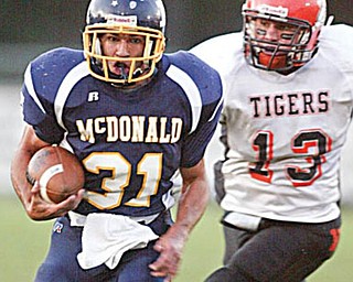 McDonald'sZach Tura eludes Wellsville's Bubba Dowling to score durings 1 rst qtr at McDonald. WDLEWIS