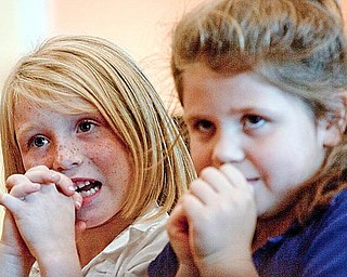 STORY TIME: First-graders Kailey May, left, and Shandi Coe listen to a story told by Regina Rees of Youngstown State University, who previously won the William Holmes McGuffey Historical Society’s Pioneer Award.