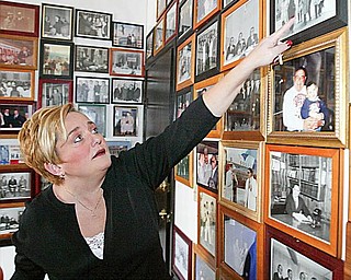 REMINISCING: Atty. Heidi Hanni looks over photos of her late father, Atty. Don L. Hanni Jr., with world and national leaders, on the walls of his office at 219 W. Boardman St. in downtown Youngstown. Unable to meet high building-maintenance and utility costs there, the Hanni law firm is moving to Boardman today.