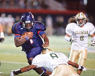 The Vindicator/Robert K. Yosay--- Fitch's Jon Ballard breaks thru the line and a tackle by Glenoak Brandon Martin during first quarter action at Fitch stadium - Ballard went on to score his 5th season rushing TD -9252009