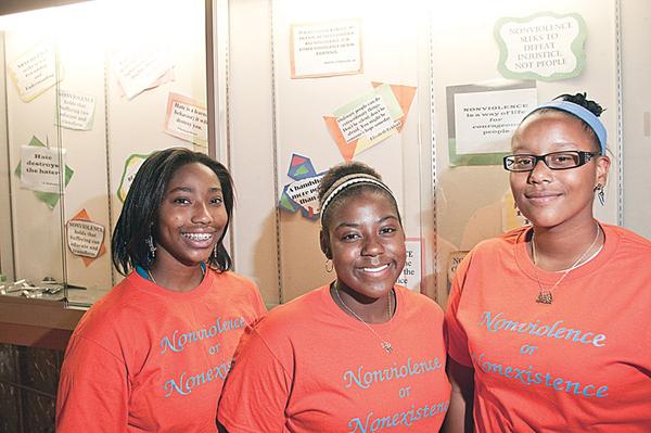 PEACEMAKERS: Youngstown students, from left, Mallory Kimble, Janae Ward and A’Ja Glover, stand in front of a message board at Chaney Middle School featuring quotes on nonviolence. The three organized a project to reduce violence in their schools. 