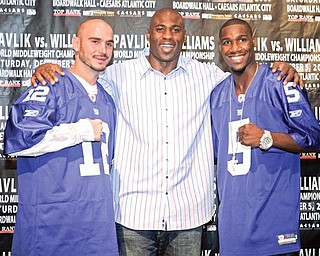 A GIANT RECEPTION: Boxers Kelly Pavlik, left, and Paul Williams, right, pose with New York Giants running back Brandon Jacobs at a news conference in East Rutherford, N.J., Tuesday, to announce their world middleweight championship fight on Dec. 5, in Atlantic City, N.J.
