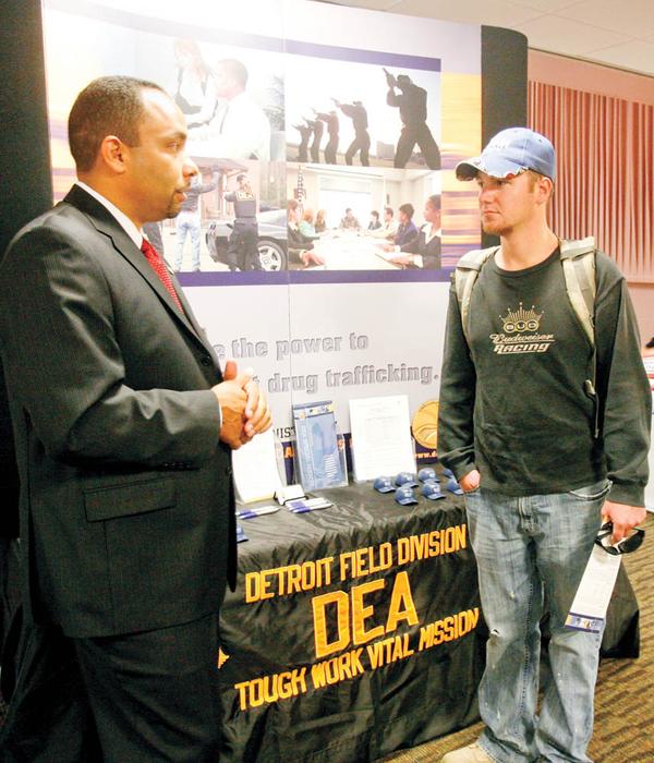 LOOKING FOR A JOB: Cory Rider, right, of Newton Falls, a junior at Youngstown State University, talks with Christopher Taylor with the Detroit office of the federal Drug Enforcement Administration about a career in law enforcement during the 2009 Job Expo at the university.