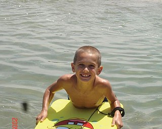 Michael Cougras, 8, of Poland boogie boards in the Atlantic Ocean at Ocean City, Md., in July.