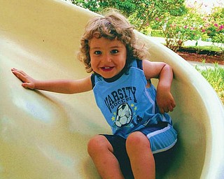 Carson John Arfaras, son of John and Lori Arfaras of Canfield, is enjoying playing on the slide when he was on vacation with his family.