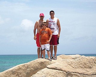 Ron, Keary and AJ Iarussi of Struthers stand on some rocks overlooking the ocean in Aruba.