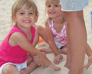 Allison and Lindsay Jones, 4, buried their cousin Isabella's feet in the sand while in Gulf Shores, Ala., in July.