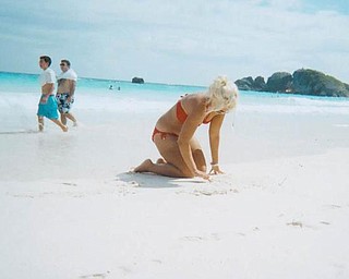 Corrie Lynn Romesburg, daughter of Darlene Romesburg of Struthers and Steve Romesburg of Warren and a YSU freshman, is shown writing in the sand at Horseshoe Bay in the Bermuda. She traveled to Bermuda to attend the wedding of her cousin.
