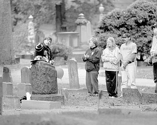 HISTORIC EVENT: Greg Ricker, points as he explains the life of J. Smith Cowden, who was buried in 1902 at Oak Hill Cemetery, near downtown Youngstown. Cowden was the third firefighter to die in the line of duty for the Youngstown Fire Department. Ricker, who is dressed as a firefighter, is part of the Mahoning and Shenango Valley Historical Club, which gave a presentation Saturday at the South Side cemetery.