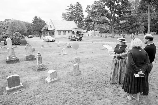 Judy Foster of Enon Valley, Pa., above right, wears a period costume as she talks to Sandy and Patrick Gatta of Poland about the life of Frederick Workman, a Gettysburg veteran who died in 1888. The Gattas said they are considering joining the historical club.