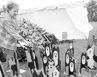FALL FEST: Crafts are on display, at left, outside a booth by D&J’s Unique Designs at Boardman Township Park. Boardman Rotary’s Oktoberfest began Saturday and continues today. Carl Angiuli and his 8-month-old daughter, Gisella, above, pose near some gourds at a booth for Angiuli’s Farm Market in Canfield. Alison Akuszewski and George Stavrenos of Boardman, right, view mums from Lutz Greenhouse in Salem.