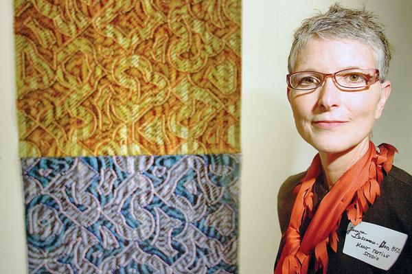 ELEMENTS: Janice Lessman-Moss, curator of the “Touch and Scale” art display, stands near her weaving combination of silk, nylon, paint and ink that she calls “Elements.” The piece is part of an exhibit of artwork from Kent State University students and faculty.