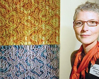 ELEMENTS: Janice Lessman-Moss, curator of the “Touch and Scale” art display, stands near her weaving combination of silk, nylon, paint and ink that she calls “Elements.” The piece is part of an exhibit of artwork from Kent State University students and faculty.
