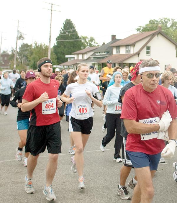 OFF AND RUNNING: Joe Scalzo, a Vindicator sports writer, left, runs his third Peace Race. Scalzo crosses the starting line Sunday on West Indianola Avenue with his wife, Tiffani, center, running her first 10-kilometer race. 